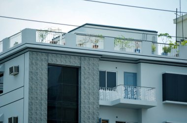 Balkonları ve cam pencereleri olan modern apartman dış tarafı, kapatın.