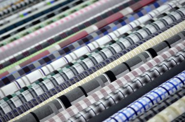 Mağazadaki bir rafta renkli kumaş örnekleri var.