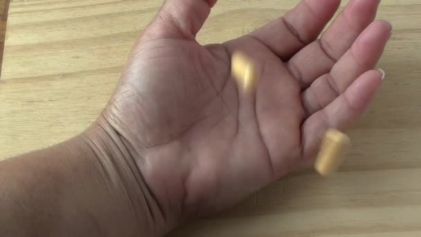 Συμπλήρωμα Κίτρινα Καψάκια Που Πέφτουν Στο Χέρι Μιας Γυναίκας Παλάμη — Αρχείο Βίντεο
