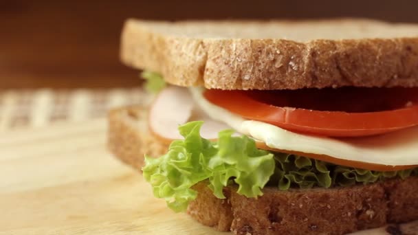 关闭健康自制三明治全麦面包 烟熏鸡胸肉和西红柿在切菜板上 — 图库视频影像