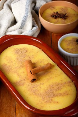 Curau, mısır tatlısı kreması ve Brezilya mutfağının tipik bir çeşidi, seramik kaseye konmuş ahşap masa. Kapat.