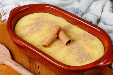 Curau, mısır tatlısı kreması ve Brezilya mutfağının tipik bir çeşidi, seramik kaseye konmuş ahşap masa. Kapat.