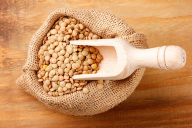 Kırsal ahşap masada kahverengi, çiğ mercimek. Üst görünüm