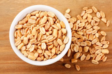 Ahşap masadaki kabukta kavrulmuş fıstık. Görüntüyü kapat