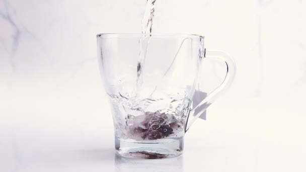 Pouring Hot Water Fruit Tea Bag Making Tea Transparent Cup — Vídeos de Stock