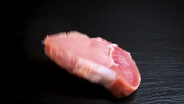 Dos Trozos Carne Cerdo Cruda Cayendo Sobre Piedra Negra Cámara — Vídeos de Stock
