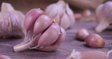 Fresh garlic with intense unique flavor and aroma on wooden background. One of the most popular ingredients of the basic recipes with nutritional properties and health benefits. Dolly shot 4k
