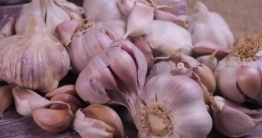 Fresh garlic with intense unique flavor and aroma on wooden background. One of the most popular ingredients of the basic recipes with nutritional properties and health benefits. Dolly shot 4k