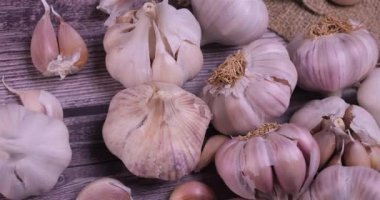 Fresh garlic with intense unique flavor and aroma on wooden background. One of the most popular ingredients of the basic recipes with nutritional properties and health benefits. Dolly shot 4k