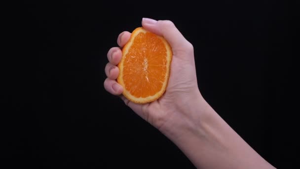 Vrouw Knijpt Een Oranje Helft Zwarte Achtergrond Citrusvruchten Bron Van — Stockvideo