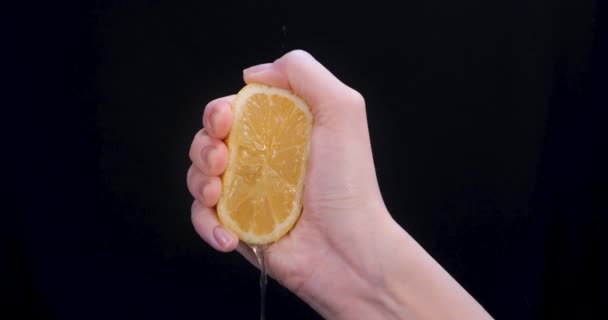 Vrouw Knijpt Een Citroen Helft Zwarte Achtergrond Citrusvruchten Bron Van — Stockvideo