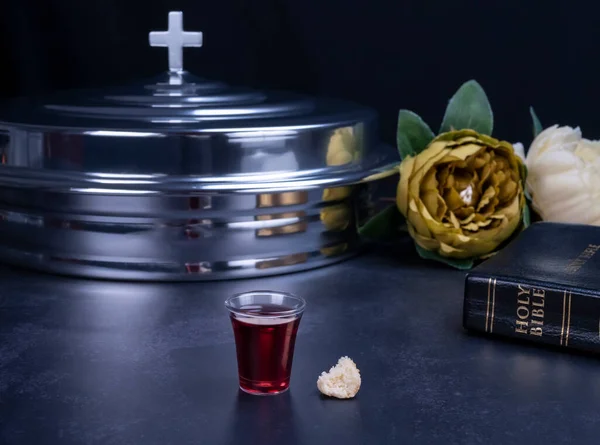 Communion glass cups on tray filled with wine the symbol of Jesus Christ blood on black background. Easter Passover and Lord Supper concept.