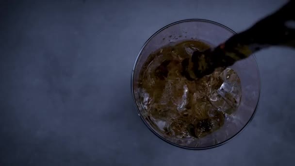氷と泡とクールなコーラの飲み物 新鮮な冷たい甘い飲み物が氷のキューブの上に注がれました ブラックに夏のリフレッシュを施したコーラグラス スローモーション — ストック動画