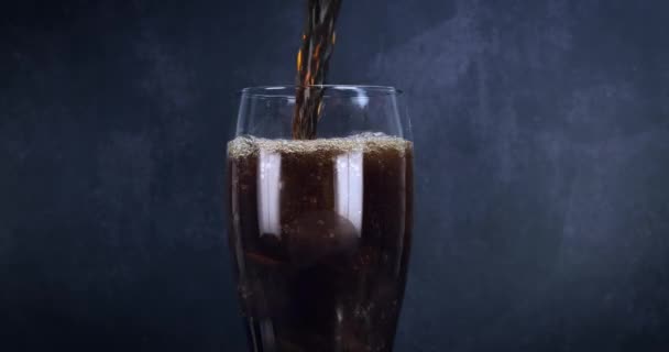 氷と泡とクールなコーラの飲み物 新鮮な冷たい甘い飲み物が氷のキューブの上に注がれました ブラックに夏のリフレッシュを施したコーラグラス ファストフォワード4K — ストック動画
