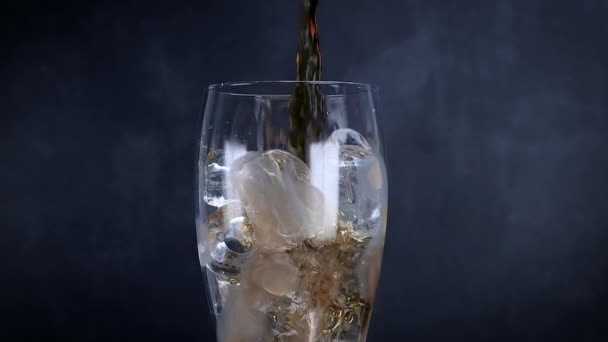 氷と泡とクールなコーラの飲み物 新鮮な冷たい甘い飲み物が氷のキューブの上に注がれました ブラックに夏のリフレッシュを施したコーラグラス スローモーション — ストック動画