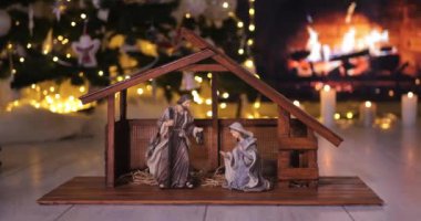 İsa 'nın doğumu figürlerini şöminenin önüne koyan kadın. Noel sahnesi. Dolly 4K çekti.