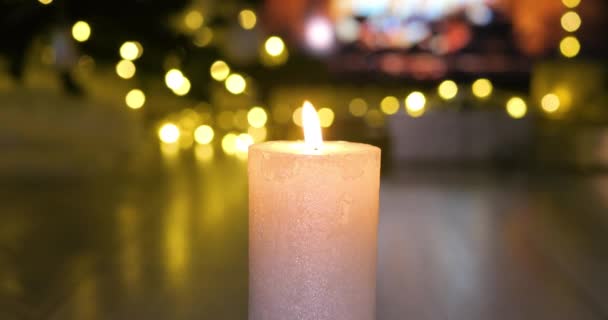 大気の灯りの暖炉の前で燃えているクリスマスキャンドル クリスマスの雰囲気のコンセプト ドリーショット4K — ストック動画