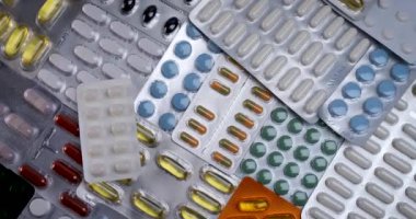 Farklı hap kılıfları, dönen arka plan. İlaçlar, haplar, antibiyotikler, vitaminler, sağlık hizmetleri, ilaç endüstrisi, uyuşturucu kullanımı, ilaç tüketimi. 4k
