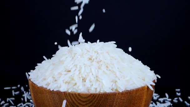 Basmati Weißer Reis Fällt Einer Hölzernen Schüssel Auf Schwarzem Sich — Stockvideo