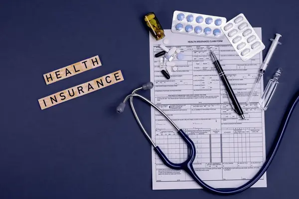 Health insurance form claim with stethoscope, pills and injection on table. Medical insurance, health risk, pay for the healthcare concept.