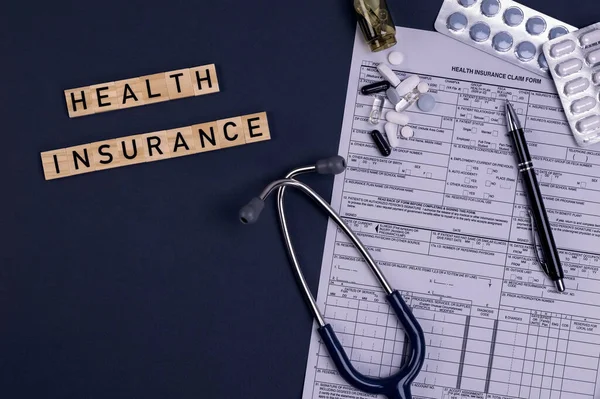 Health insurance form claim with stethoscope and pills on table. Medical insurance, health risk, pay for the healthcare concept.