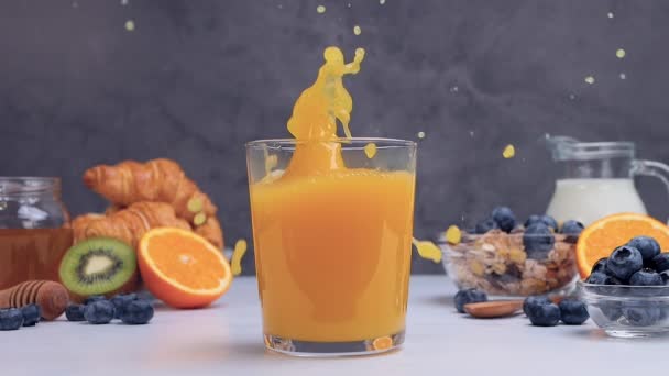 橙片掉进新鲜的橙汁里 早餐喝健康的饮料 溅满维生素的饮料对免疫系统的健康有好处 慢动作 — 图库视频影像