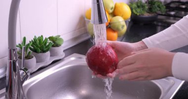 Islak siyah arka planda dönen kırmızı taze elma. Sağlıklı çiğ organik yiyecekler, vitaminler, meyve konsepti. 4k