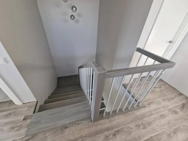 Modern gray wooden stairs with wooden railing of modern stylish house