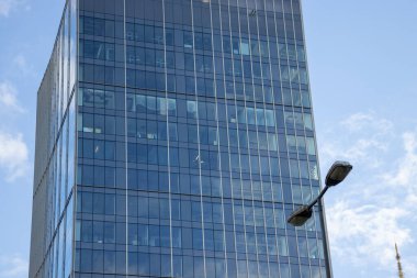 Modern cam cephe. İş bölgesindeki bir binanın alt manzarası. Bir ofis binasının cam cephesi.