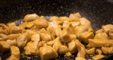 Tavada ince dilimlenmiş tavuk.