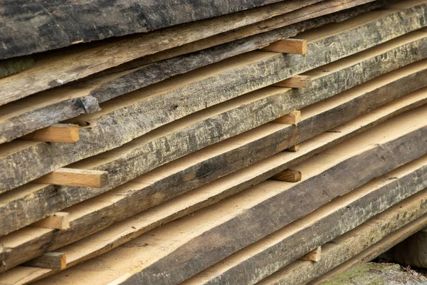 Piled lumber near a lumber mill. Lumber and wood slice. Stacked lumber. Folded wood.Closeup wooden board