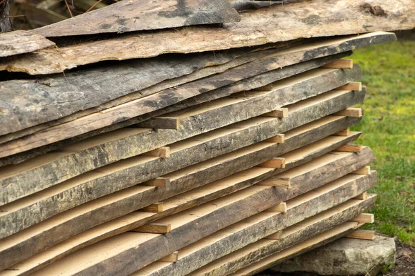 Piled lumber near a lumber mill. Lumber and wood slice. Stacked lumber. Folded wood.Closeup wooden board