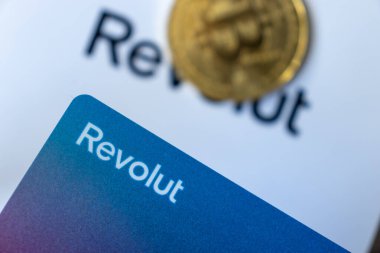 Warsaw Poland - February 18, 2023: Bitcoin and Revolut card logo. Crypto business. Banking concept