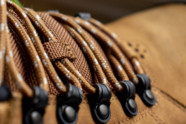 Close up shoelace on leather shoe. Brown shoe detail background. Thread sew pattern. Fashion background. 