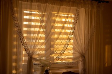 Gün batımı perdesi. Ev odası. Yazın gece penceredeki şeffaf perdeden yatak odasına ışık tut.