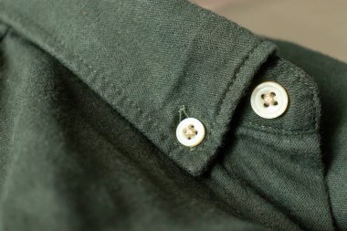 Erkek gömleklerinden birini kapat. Gömleğin düğmesi. Kıyafet arka planı. Tam çerçeve