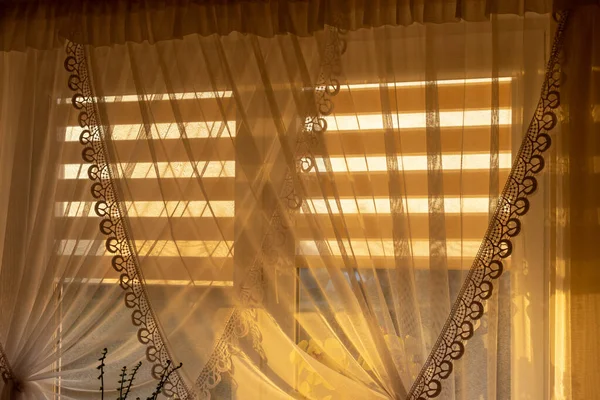 遮挡室内落日 在夏夜时分 透过透明的窗帘 把灯光透过窗户射进卧室 — 图库照片
