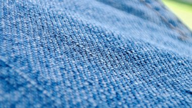 Close-up shot of denim jeans fabric texture in vibrant blue.