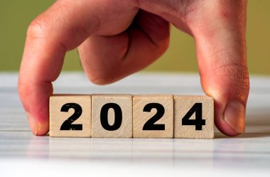 2024 'e hoş geldiniz: Yeni yılı neşeli elementlerle tasvir eden sayısal tahta bloklar.