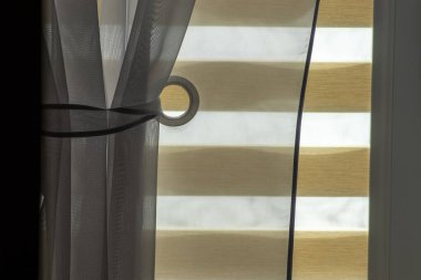 Işıl ışıl bir iç mekan, güzel perdeler ve tekerlekli paten ile kaplı bir pencere..