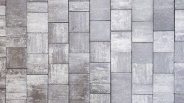 Gri beton tuğla döşeme desenli bir yüzey yolu oluşturuyor.