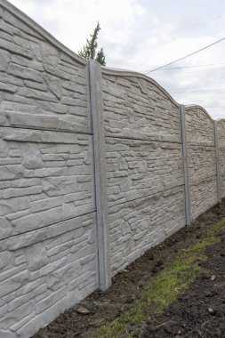 Panellerden beton çitler. Bahçesinde gri bir çit olan dekoratif çitler. Desenli