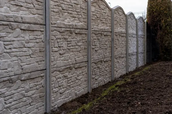 Panellerden beton çitler. Bahçesinde gri bir çit olan dekoratif çitler. Desenli