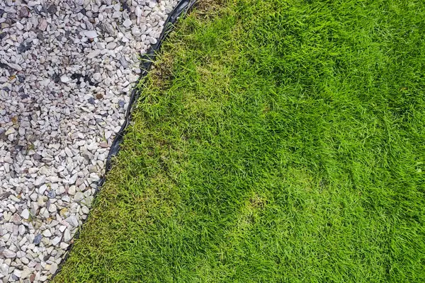 Ev bahçesinde çakıl ve çimen. Bahçıvanlık konsepti. Bahçe kenarı Yazın kapanıyor