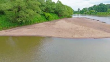 Nehir manzaralı küçük bir sahil. Kum ve nehir dibi. Nehir seviyesi düşük