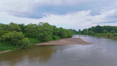Nehir manzaralı küçük bir sahil. Kum ve nehir dibi. Nehir seviyesi düşük