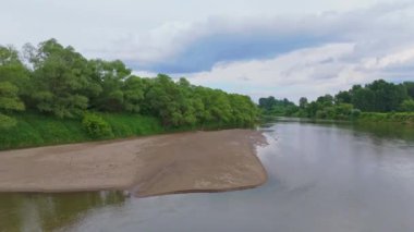 Nehir manzaralı küçük bir sahil. Kum ve nehir dibi. Nehir seviyesi düşük