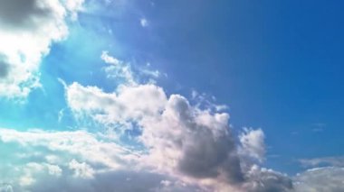 Kümülüs bulutlarının mavi gökyüzünde hareket etme zamanı. Zaman aşımı, güneş ışınları gün ışığı, güneşli bulutlar