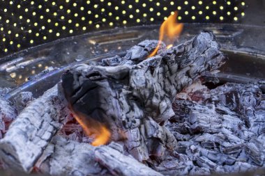 Parlayan közlerin ve alevlerin yakın çekimi sıcak ve davetkar bir atmosfer yaratır. Kamp yapmak ya da dışarıda toplanmak için ideal.