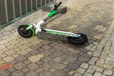 Varşova, Polonya - 1 Ekim 2023: Bir Lime elektrikli scooter modern şehirlerde kentsel ulaşım seçeneklerini sergileyerek kaldırımda yatmaktadır. Çevre dostu iş seyahati için mükemmel.